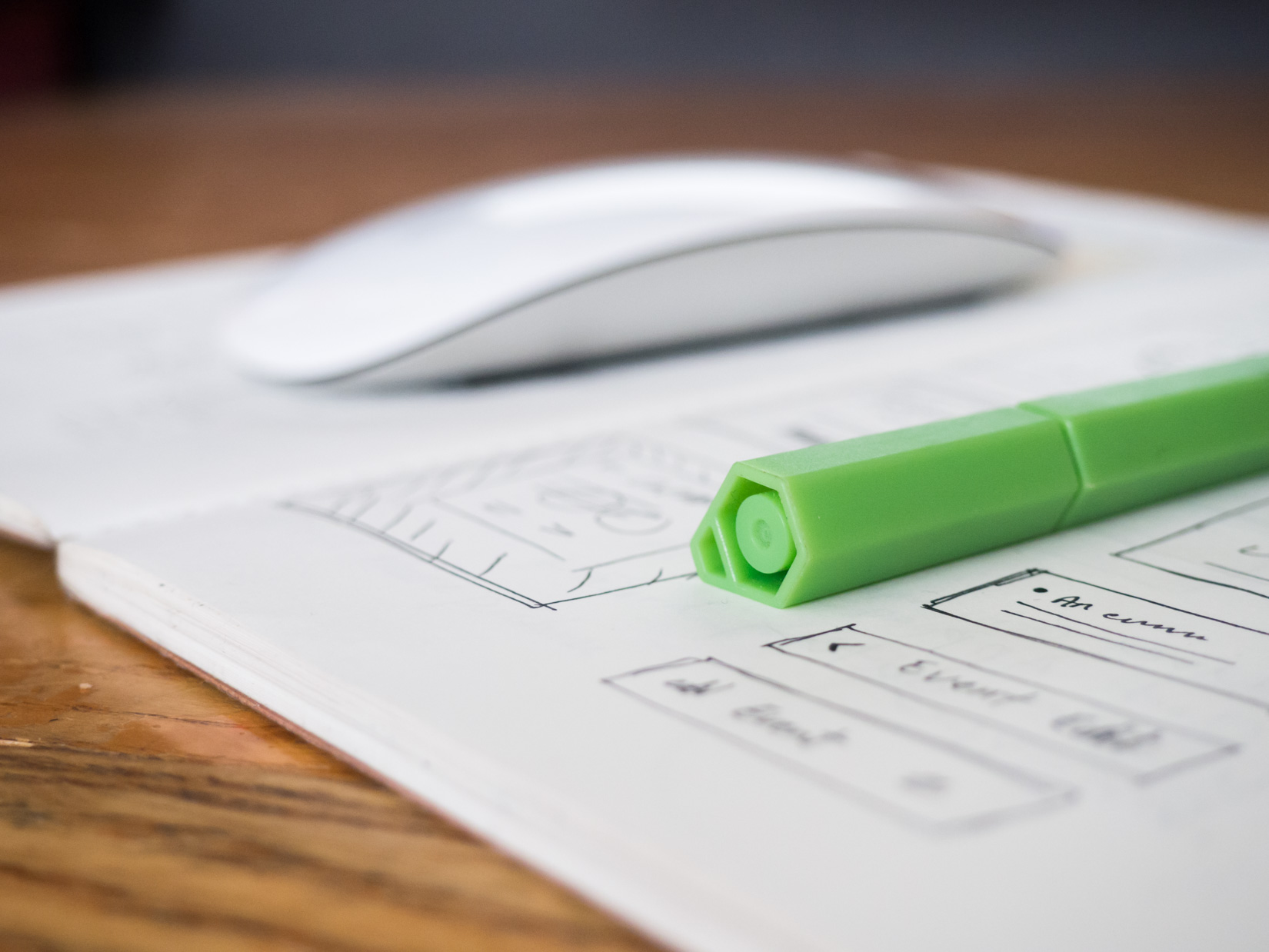 Green Pen and Sketchbook on Desk