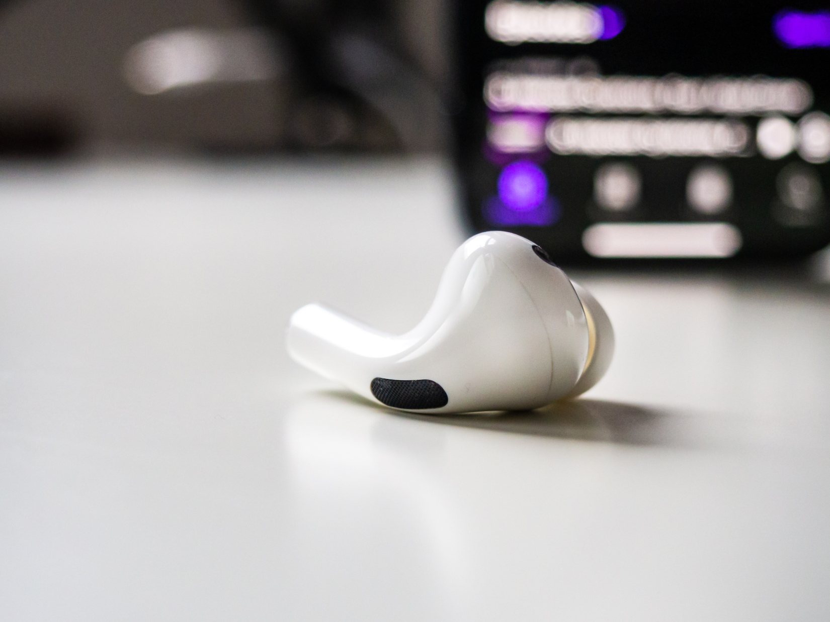 Earbud on White Desk with Phone